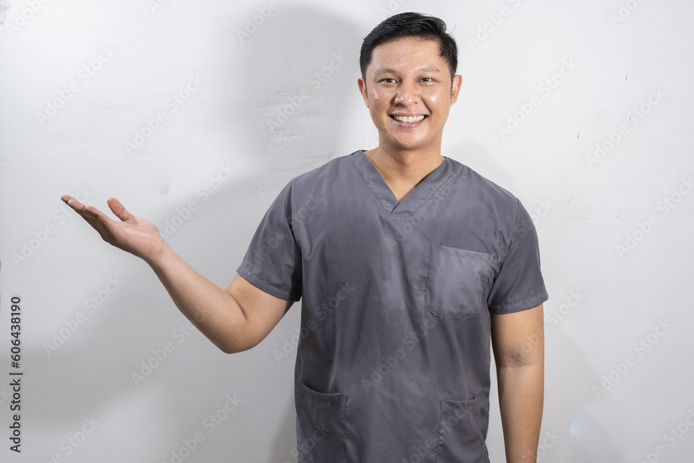 Asian male medic showing something while smiling, showing something concept Asian male medic showing something while smiling, showing something concept