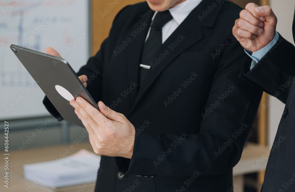 Financial analysts analyze business financial reports on a digital tablet planning investment project during a discussion at a meeting of corporate showing the results of their successful teamwork. Financial analysts analyze business financial reports on a digital tablet planning investment project during a discussion at a meeting of corporate showing the results of their successful teamwork.