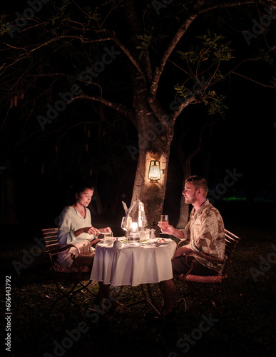 couple men and romantic woman having dinner on a luxury safari, in South Africa l, a luxury safari lodge in the bush of a Game reserve photo