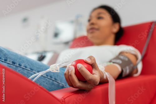 Foto selective focus of medical rubber ball in hand of multiracial woman donating blo