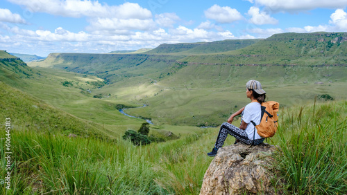 women on a hiking trip in the mountains, Drakensberg Mountain South Africa during summer, Central Drakensberg Kwazulu Natal, view over green mountains in South Africa at sunset