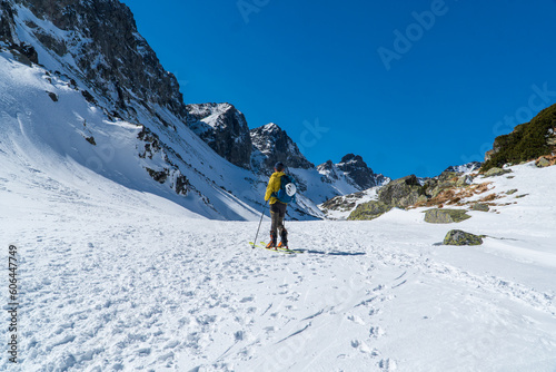 A skier is walking up the hill. Skitouring in Alps. Sunny weather.