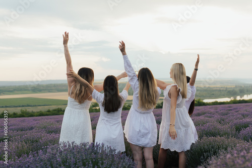 Free women with open arms enjoying the moment in the lavender field in France. Harmony and people concept. 