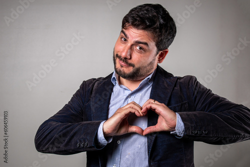 Hombre elegante formando un corazón con las manos en señal de amor y gusto photo