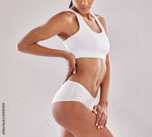 Body, wellness and woman in underwear in studio for diet, positivity and self love on grey background. Detox, beauty and female model with slim, stomach or bodycare in lingerie posing with confidence