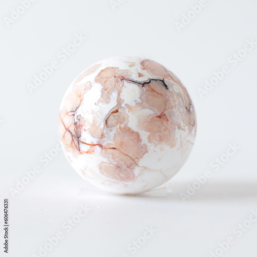 Sakura Agate Healing Stone on a white background Crystals sphere on a white background