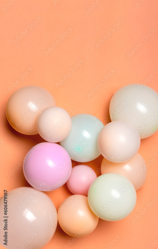 Vertical image of balloons in pastel colors on the orange empty surface Vertical image of balloons in pastel colors on the orange empty surface