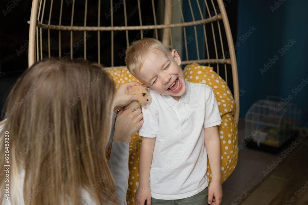 Young woman holding pet and showing to cheerful child Young woman holding pet and showing to cheerful child