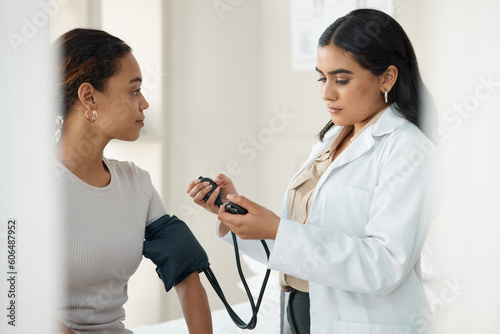 Healthcare, blood pressure and doctor with a patient for a consultation in the hospital. Medicine, equipment and medical worker checking hypertension of a woman at a checkup in a medicare clinic. photo