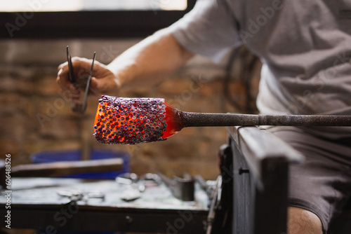 Artigiano realizza un vaso in vetro soffiato a murano
 photo