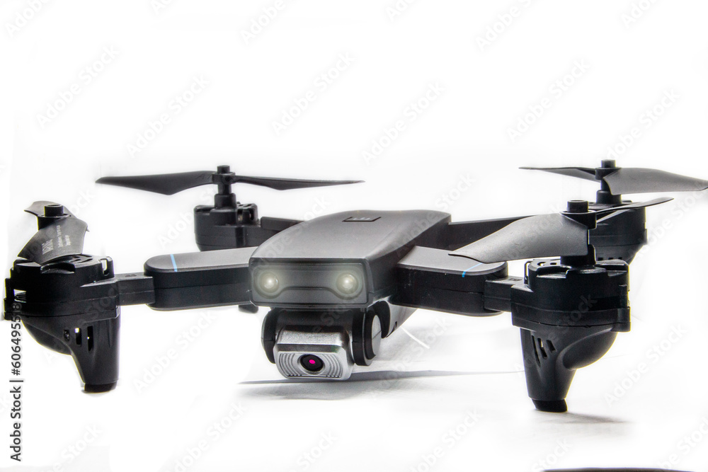 dark gray quadrocopter on a white background with glowing headlights and glare
dark gray quadrocopter on a white background with glowing headlights and glare
