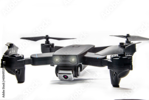 dark gray quadrocopter on a white background with glowing headlights and glare 