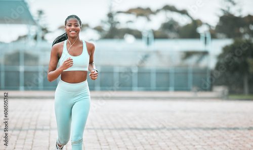 Fototapeta Naklejka Na Ścianę i Meble -  Portrait, city and black woman running, workout goal and exercise for wellness, sports and training. Face, female person and runner with earphones, cardio and athlete with self care and stress relief