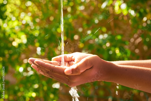 Fresh water splashing into Black woman cups hands, World Water Day save water