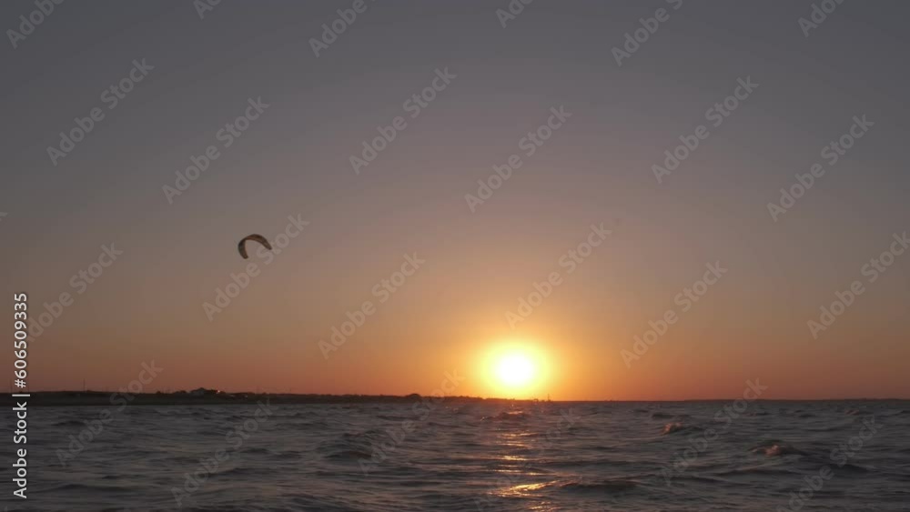 Man on the kiteboard rides in the evening Man on the kiteboard rides in the evening