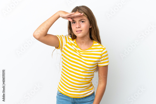 Little caucasian girl isolated on white background looking far away with hand to look something