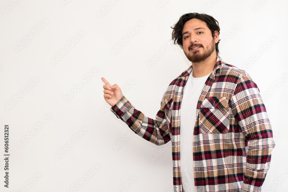 Portrait of hispanic man making pointed finger to empty space in the left with copy space in white background Portrait of hispanic man making pointed finger to empty space in the left with copy space in white background