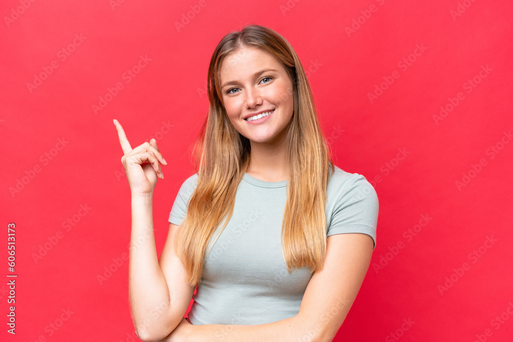 Young beautiful woman isolated on red background happy and pointing up Young beautiful woman isolated on red background happy and pointing up