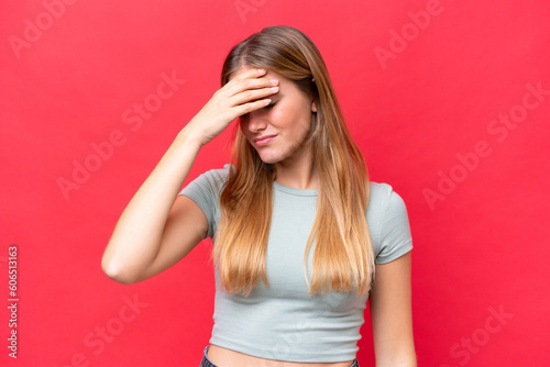 Young beautiful woman isolated on red background with headache