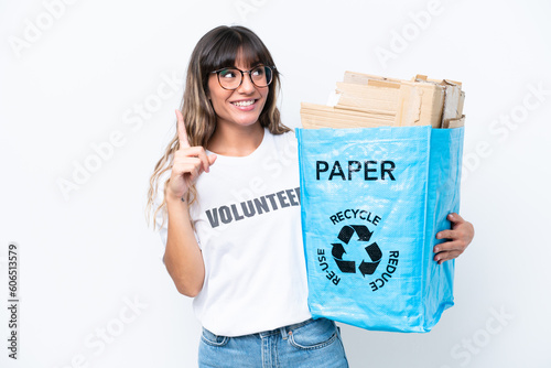 Young caucasian woman holding a recycling bag full of paper to recycle isolated on white background intending to realizes the solution while lifting a finger up