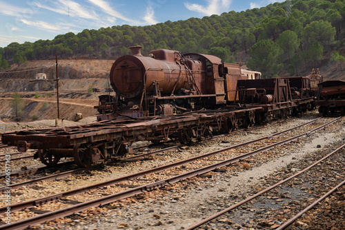 Steam engine and freight cars rusting on tracks outside. Train at Rio Tinto
