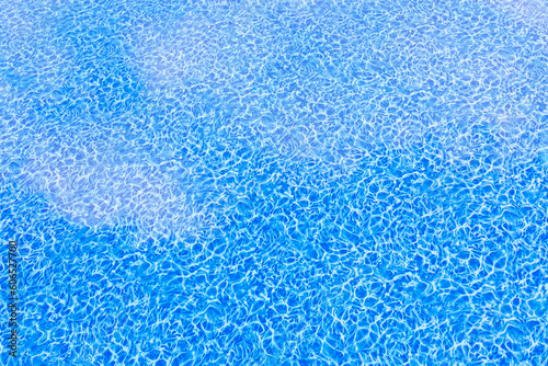 Sky with clouds are reflected in clear blue pool