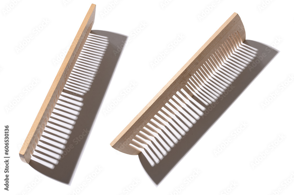 Wooden comb made of natural material with hard shadow. On a white background. Wooden comb made of natural material with hard shadow. On a white background.