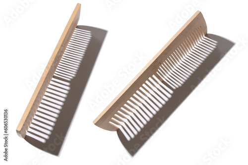 Wooden comb made of natural material with hard shadow. On a white background.