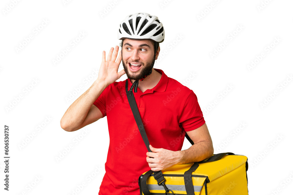 Young delivery man with thermal backpack over isolated chroma key background listening to something by putting hand on the ear Young delivery man with thermal backpack over isolated chroma key background listening to something by putting hand on the ear