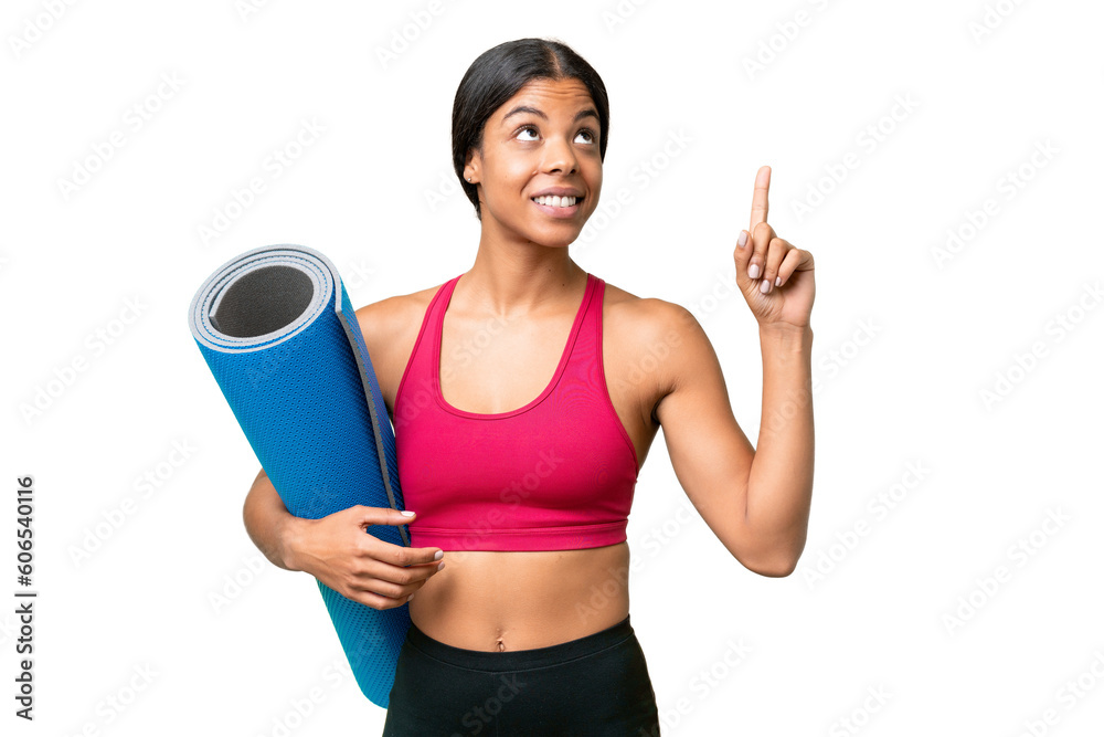 Young sport African American woman going to yoga classes while holding a mat over isolated background pointing up a great idea