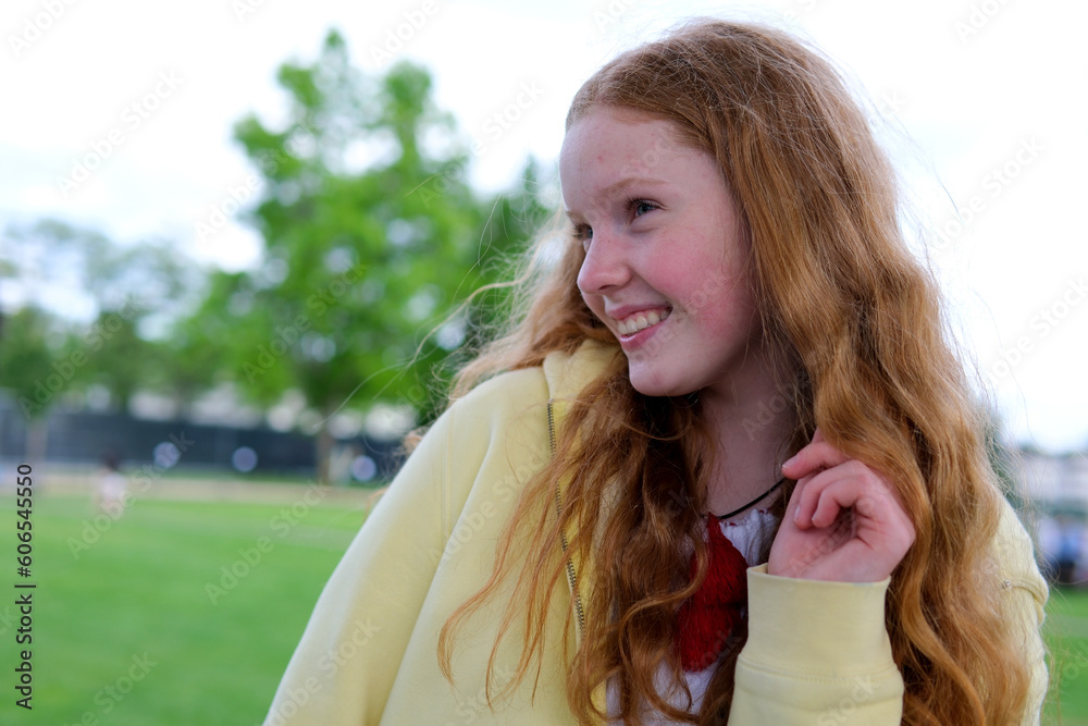 Φωτογραφία red-haired teenager girl against background of trees to be embarrassed to burst