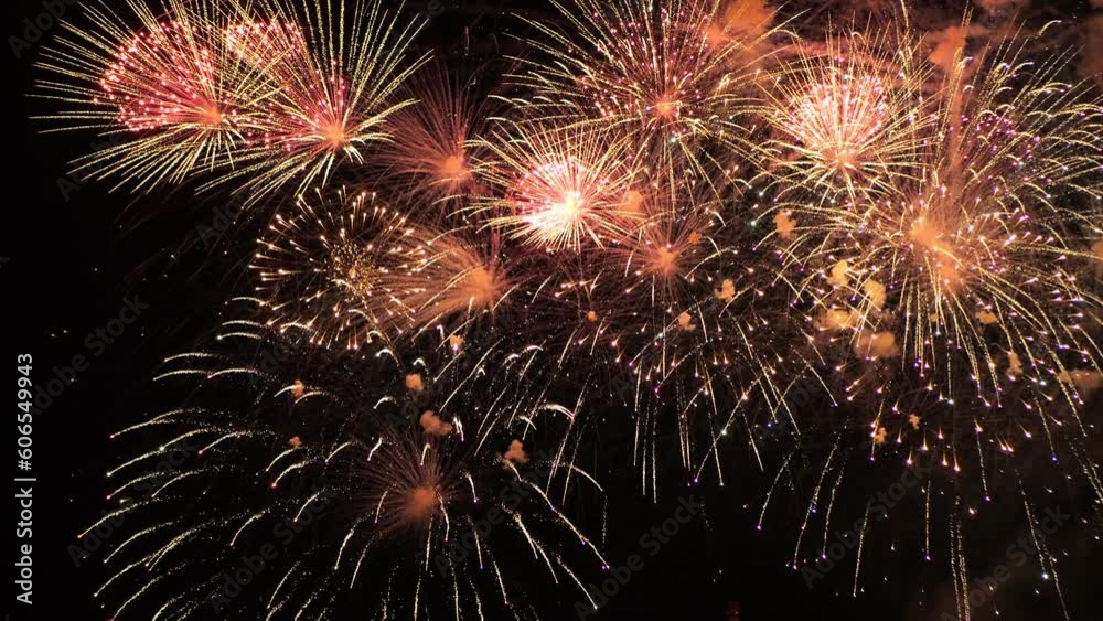 Golden and pink flashes of fireworks sparkling against the black night sky. Golden and pink flashes of fireworks sparkling against the black night sky.