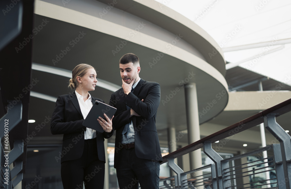 Young business couple discussing and using tablet to discuss work outside the office Young business couple discussing and using tablet to discuss work outside the office