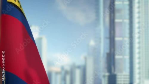 hanging Liechtenstein flag on city backdrop with blue sky photo