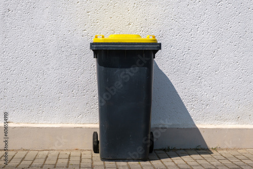 Yellow dustbin or trash can or black dustbin or trash can with yellow lid photo