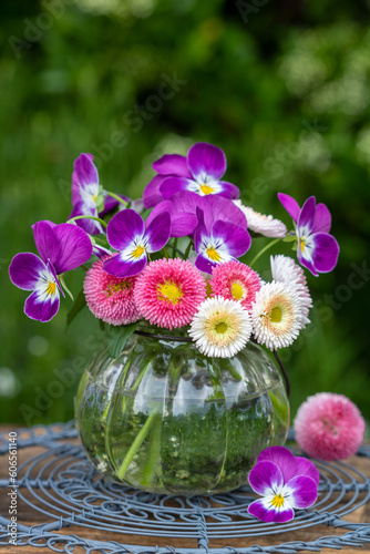 Blumenstrauß mit Bellis perennis und Hornveilchen in Pink in Glasvase 