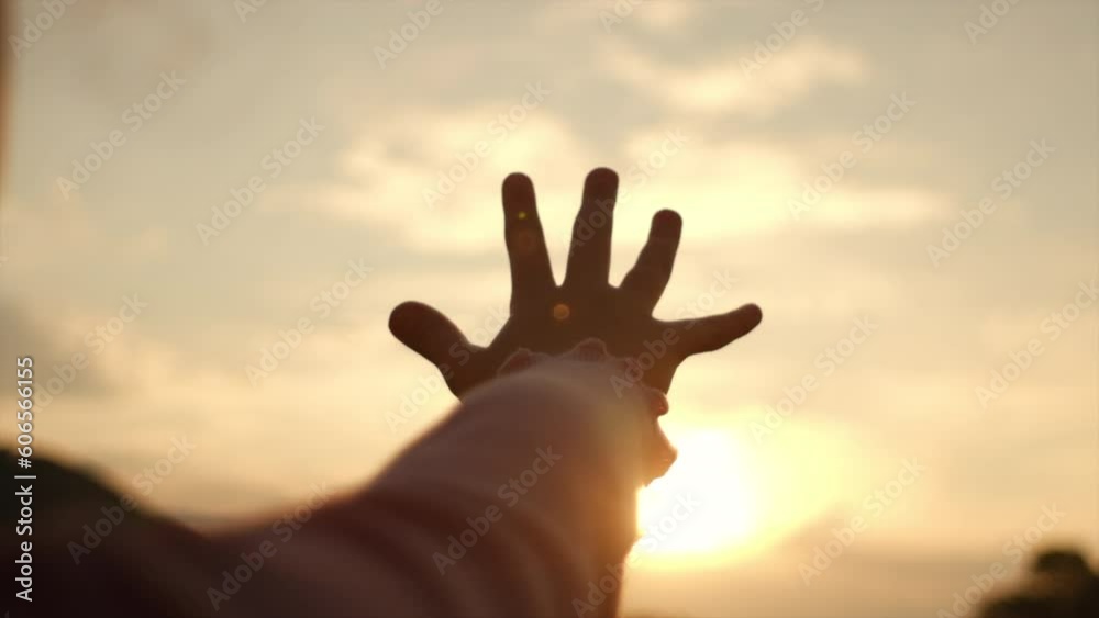 Little girl raising hand over sunset sky, enjoying life and nature. Child on summer field enjoying sunlight. Silhouette of preteen kid in sunlight rays. Air, environment concept. Dream of flying