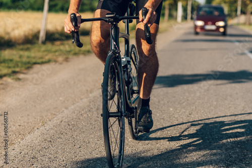 Unrecognizable man riding a bicycle on a road during a race