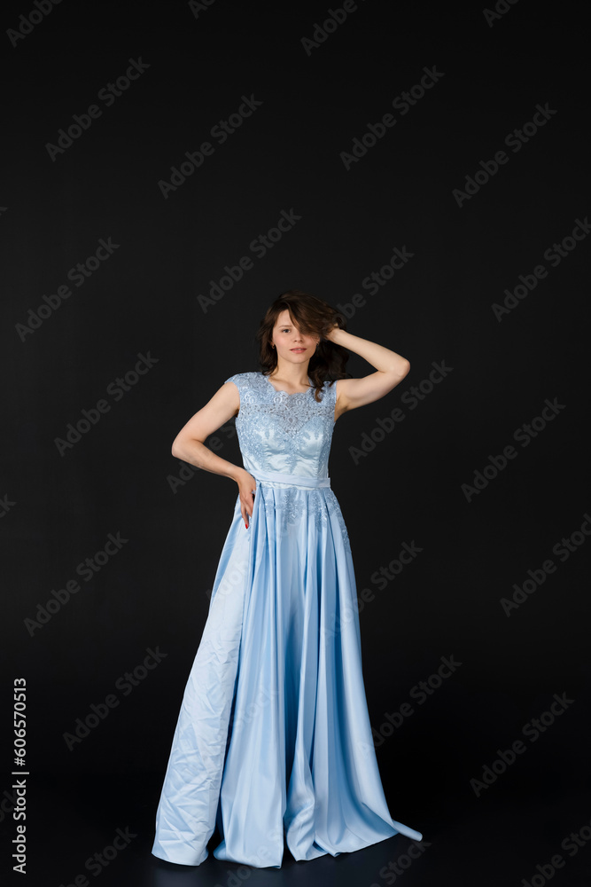 Beautiful young Bridesmaid in blue dress, posing. isolated on black background.