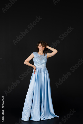 Beautiful young Bridesmaid in blue dress  posing. isolated on black background.