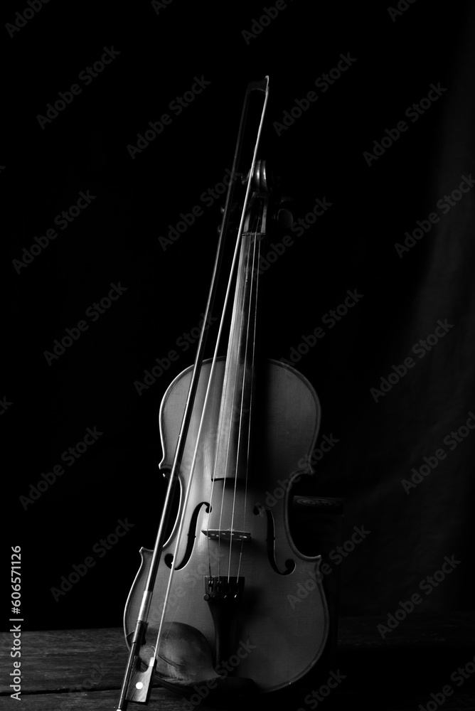 Violin, details of a beautiful violin in black and white on rustic wood, low key style photo, black background, selective focus. Violin, details of a beautiful violin in black and white on rustic wood, low key style photo, black background, selective focus.