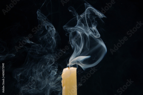 Smoke from an extinguished candle on a dark background. The concept of spirituality and the end of life. photo