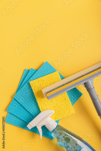 Set for cleaning windows on yellow background. Concept of Housekeeping, professional clean service, housework kit supplies. Top view, flat lay with free copy space