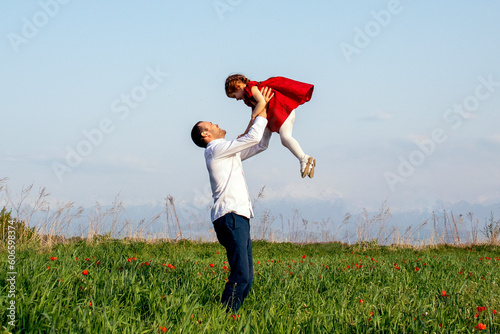 dad throws his daughter in a poppy field