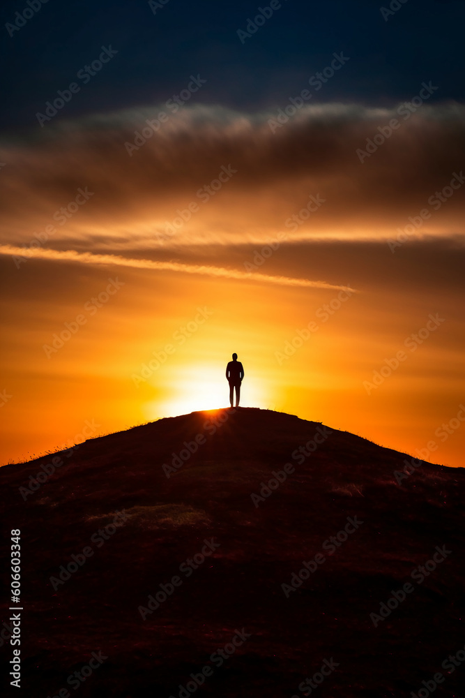 A dramatic silhouette of a person standing on a hill. AI generative