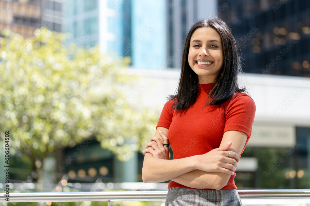 Obraz na plátně Portrait of smart smiling Indian student with arms crossed looking at camera in university campus, education concept