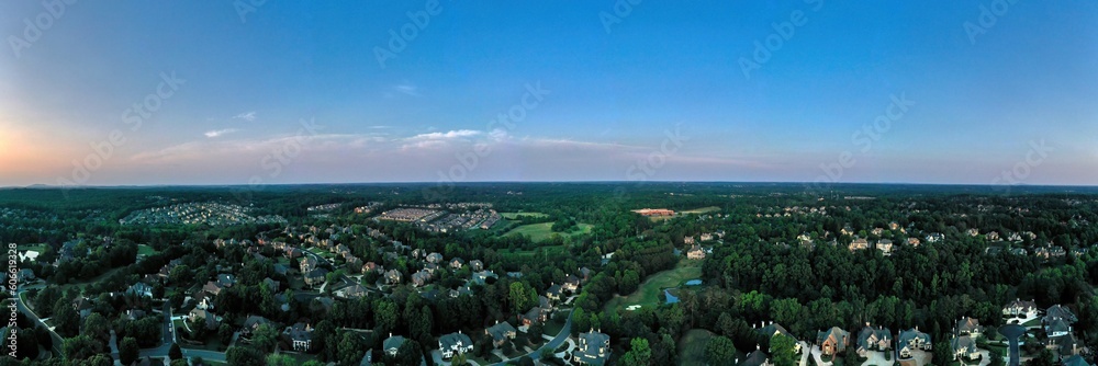 180 degree Aerial panoramic view of an upscale subdivision shot during golden hour.