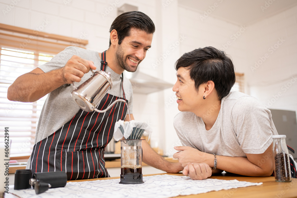 Cheerful Boyfriends gay LGBTQ lovely couple making a drip coffee brew in the kitchen together for breakfast. Cheerful Boyfriends gay LGBTQ lovely couple making a drip coffee brew in the kitchen together for breakfast.