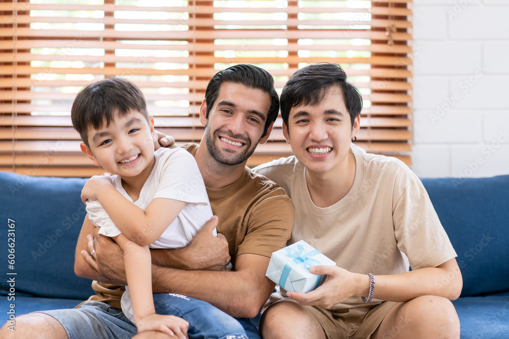 Loving LGBTQ Family Playing with Toys with Adorable child Boy at Home on Living Room sofa. Cheerful Gay Couple Nurturing a Child. Concept of Diverse Childhood, New Life, Parenthood. Loving LGBTQ Family Playing with Toys with Adorable child Boy at Home on Living Room sofa. Cheerful Gay Couple Nurturing a Child. Concept of Diverse Childhood, New Life, Parenthood.