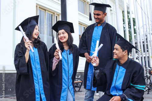 Group of graduates friends chatting after getting their university diploma on graduation day photo